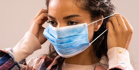 Woman Putting Surgical Mask On